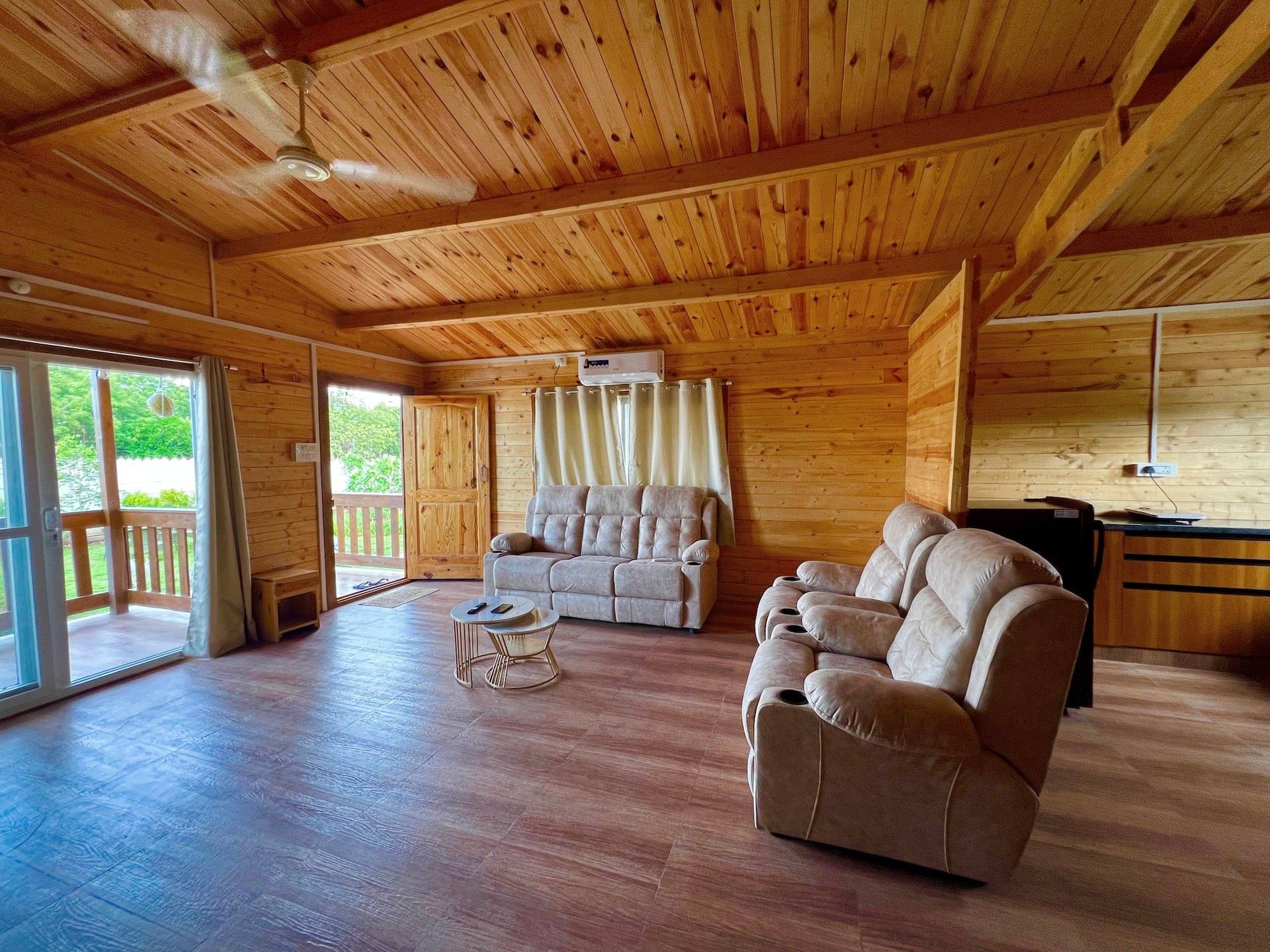 Wood-panelled living room with recliners and a sofa