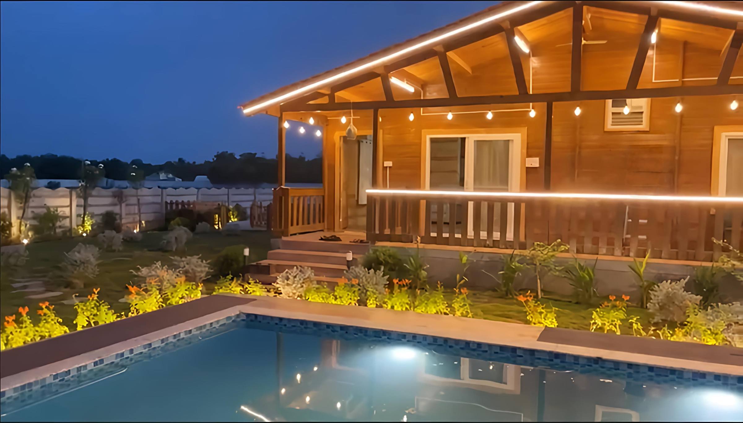 Wooden cottage glowing with warm lights after sunset